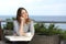 Woman pensive sitting in a terrace of a restaurant