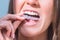 Woman with perfect smile inserting invisible dental aligners for dental correction