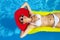 Woman with perfect tanned body lying on yellow air mattress in t