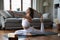 Woman perform yoga asanas on mat in living room