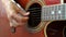 Woman performer hand play on guitar with fretboard