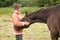 Woman pets horse.