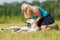 Woman pets a labrador at the belly