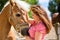 Woman petting horse on pony farm