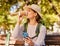 Woman, phone and coffee in relax for backpacking on park bench for nature adventure in the outdoors. Female hiker or