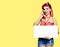 Woman with phone, in pin up, showing blank signboard, mock up copy space free area. Yellow background. Girl. Retro, vintage