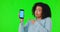 Woman, phone and pointing finger at mockup on green screen for bad review or poor service. Confused african female