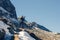 A woman photographer with camera in a winter jacket with fur stands on the snow mountain in Switzerland. Fluela pass