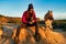 Woman Photographer Capturing Dog Sitting in Landscape with Clear Sky. With Copy space