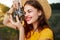 Woman photographer in hat looking into the camera lens smile nature hobby
