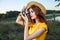 Woman photographer in hat looking into the camera lens smile nature hobby