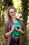 Woman photographer with hipster style glasses taking pictures in park with retro camera.