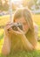 Woman the photographer with old camera lays on a grass