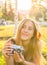 Woman the photographer with old camera lays on a grass