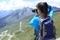 Woman photographer taking photo at plateau mountain peak in tibet,china