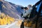 Woman photographing with camera beautiful landscape. Happy tourist travelling in countryside.