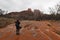 Woman photographing Cathedral Rock in Red Rock State Park outside of Sedona, Arizona on cloudy snowy winter day.