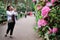 Woman photographing flowers in Rhododendrons Park in Helsinki, Finland.