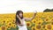 Woman photographing herself phone photo girl on a background of sunflowers, share your photos online