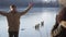 Woman photographing man posing by frozen lake