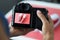 Woman photographing red sports shoes on professional camera closeup