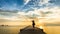 Woman photographing sunset on the pier in the sea