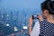 Woman photographing a view of the twilight Bangkok