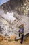 Woman photographing volcano crater