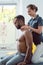 Woman physical therapist massaging young black man