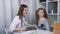 A woman physician examines a sore throat for a little girl patient. Mother and young daughter at a reception at the