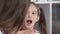 A woman physician examines a sore throat for a little girl patient. Mother and young daughter at a reception at the