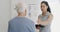 Woman physiotherapist, elderly man and shoulder pain with tablet and medical support in a clinic. Physical therapy