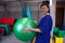 Woman physiotherapist with fitball in rehabilitation center