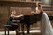 Woman pianist sits at the piano and beautiful singer