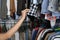 Woman picking clothes from rack, closeup. Fast fashion