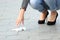 Woman picking garbage of the sidewalk on the street