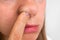 Woman is picking her nose with finger inside