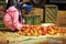 Woman picking red apples. Market. Skoura. Morocco.