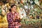 Woman picking ripe apples on farm. Farmer grabbing apples from tree in orchard. Fresh healthy fruits ready to pick on fall season