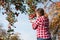 Woman picking ripe apples on farm. Farmer grabbing apples from tree in orchard. Fresh healthy fruits ready to pick on fall season