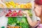 Woman picking some fruit on full fridge