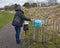 A Woman picking up an Information Leaflet at the start of the Riverside Nature trail in Dundee.