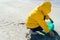 Woman picking up plastic crouched on the beach