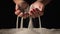 Woman picks up clean white sand in her palms and sprinkles it through her fingers. Female hands playing with sand on