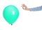 Woman piercing green balloon on white background