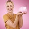 Woman, piggy bank and portrait for savings on pink background, studio and backdrop. Happy female holding financial tin