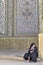 Woman pilgrim dressed in Islamic clothing, sitting inside holy p