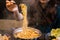 Woman pinching boiled Korean Instant Noodle in the air with chopsticks from steaming hot pot