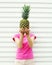 Woman and pineapple on her head standing over white