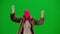 Woman in pink balaclava, tiger fur coat and evening dress walking and dancing merrily with her hands up. Woman freak on